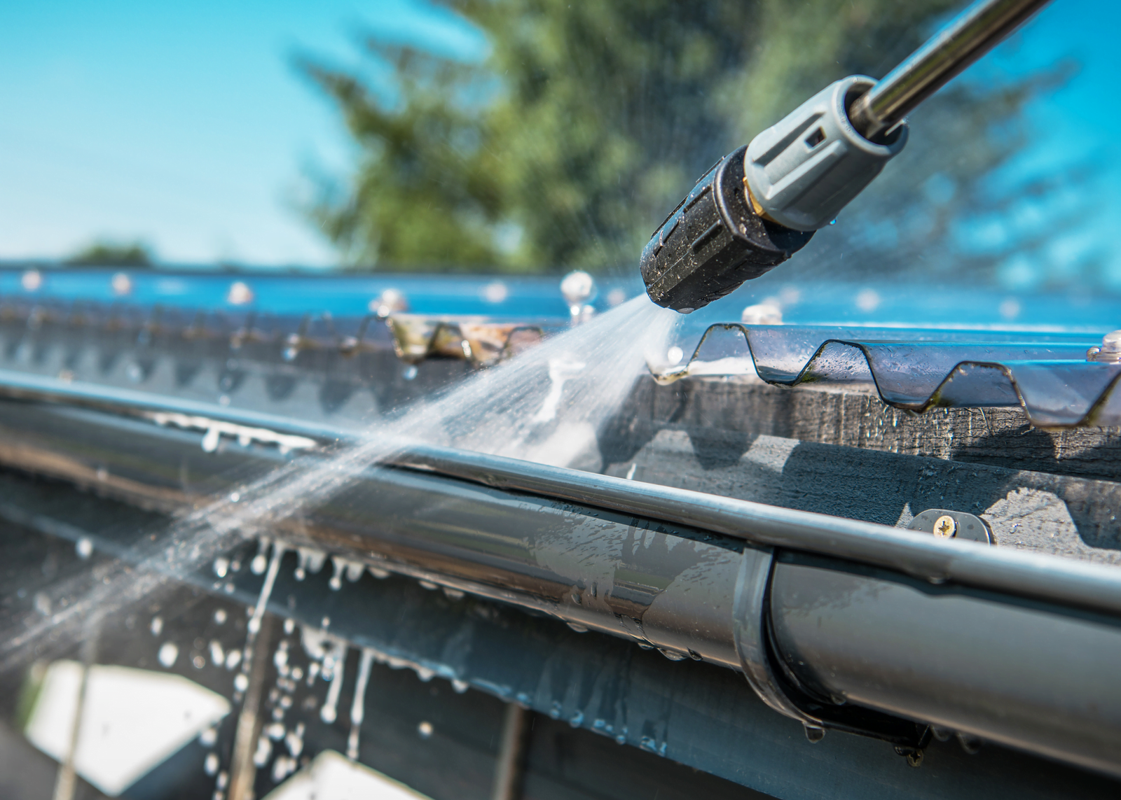 Spring Gutter Cleaning in Jacksonville, FL by Handyman Jax Closeup of spring rain gutters being cleaned using a pressure washer, part of Handyman Jax's gutter cleaning services in Jacksonville, FL
