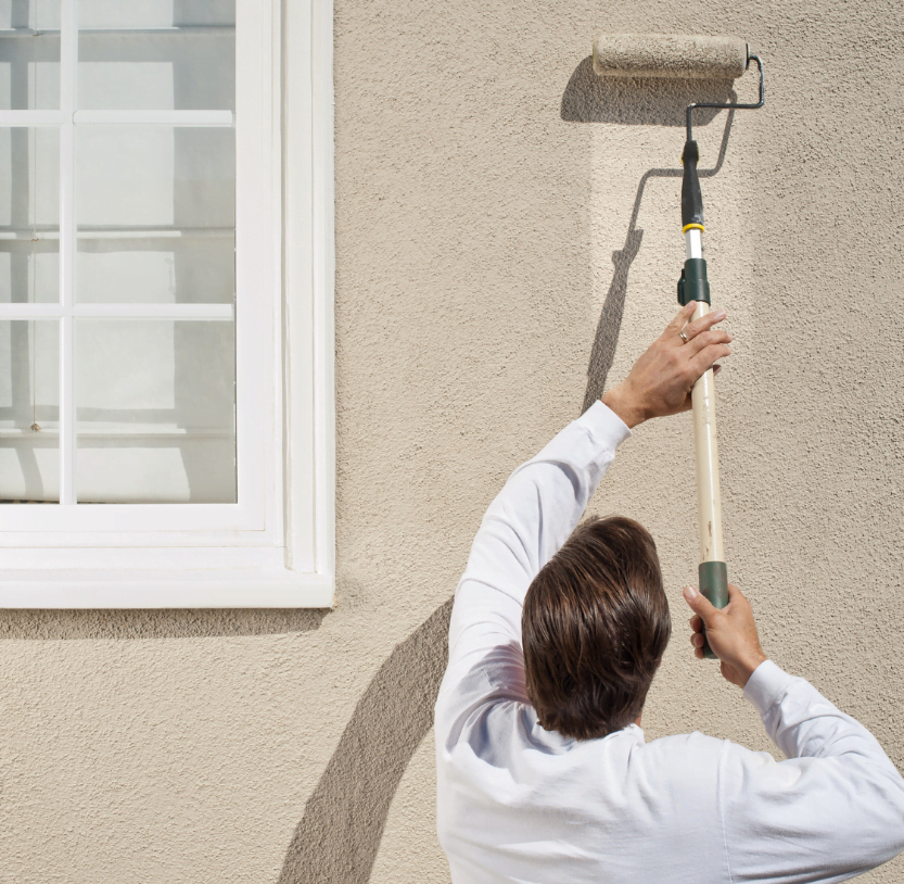 Worker painting exterior wall, Ocala Handyman Co.'s quality painting services in Ocala, FL.
