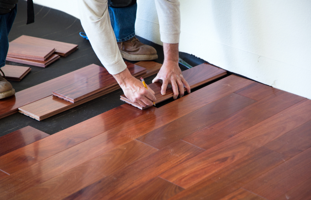A worker installing hardwood floor in an American upscale homeA worker installing hardwood floor in an American upscale home A worker installing hardwood floor in an American upscale homeA worker installing hardwood floor in an American upscale home